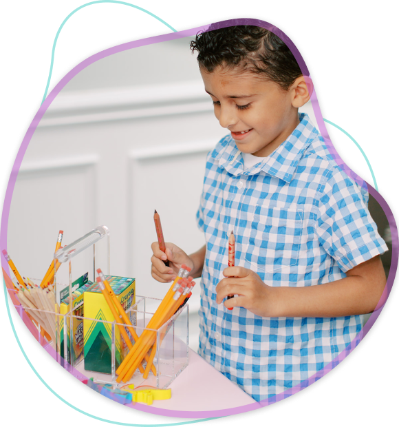 Child holding pencils and crayons